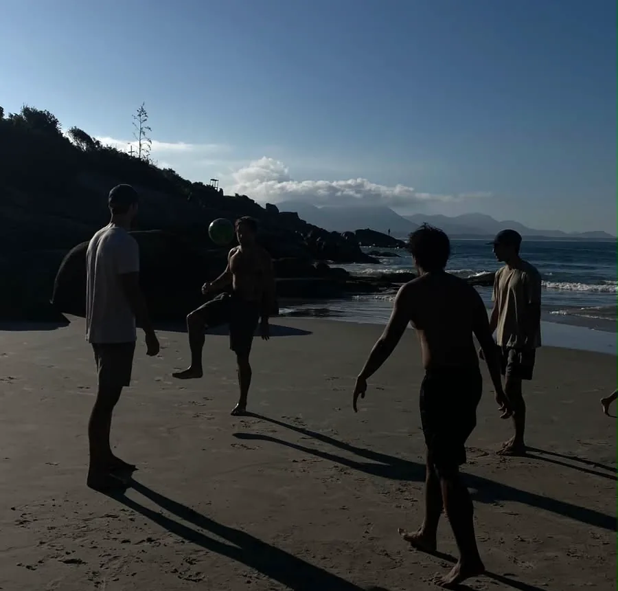 Beach football at dusk, silhouetted figures